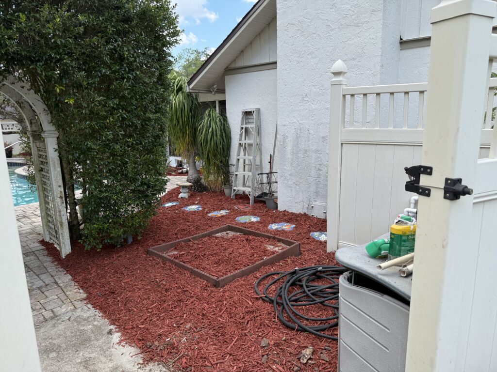 Front entry paver walkway with red mulch foundation bed in progress at Ocala FL home