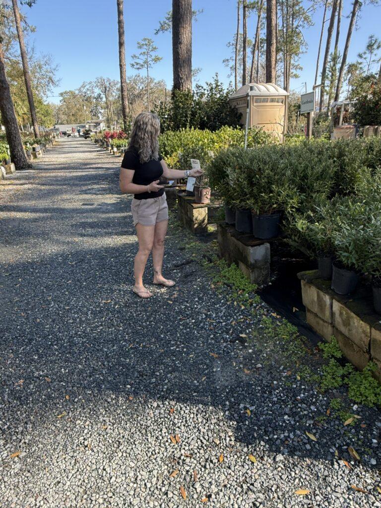 D&T crew member walking nursery path with plants selected for Ocala FL install