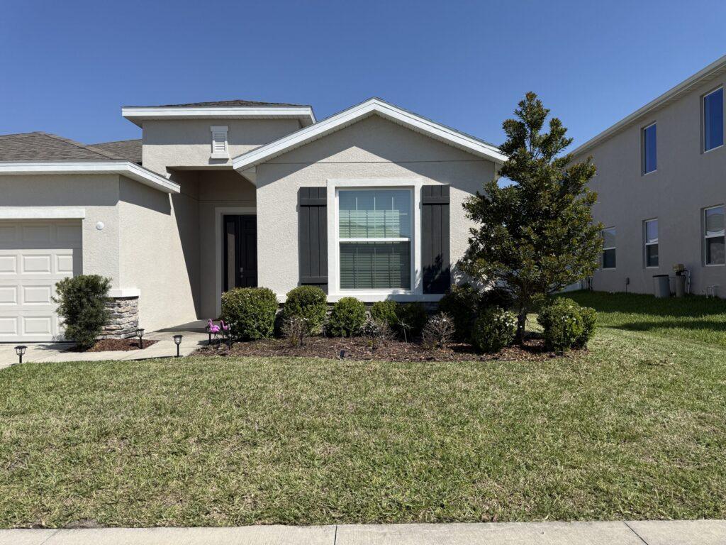 Home front with shaped foundation shrubs and palm in Ocala FL