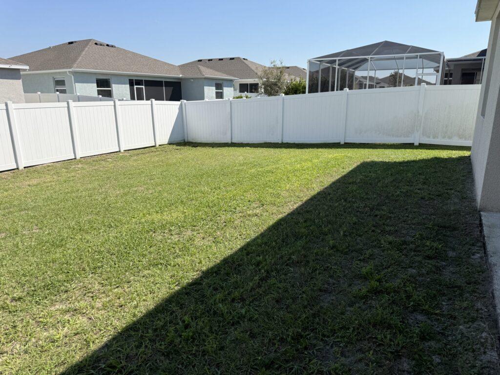 Fenced backyard with freshly mowed green lawn and trimmed edges in Ocala FL