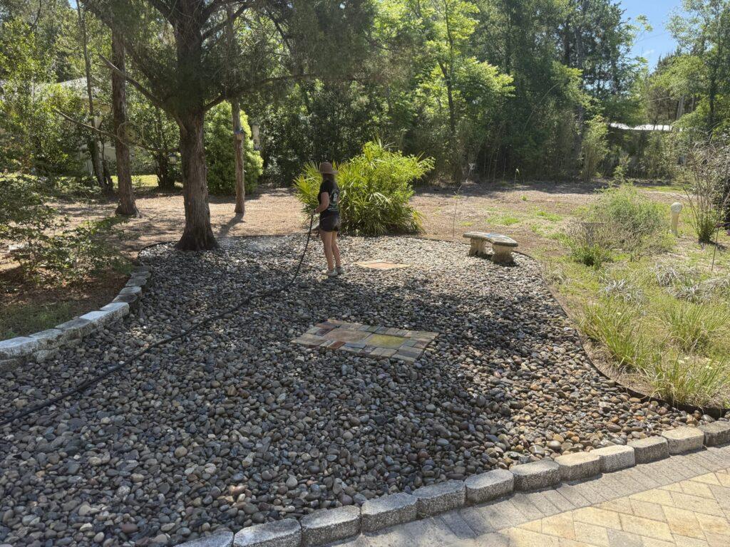 Finished river rock garden pathway with crew member walking through in Ocala FL