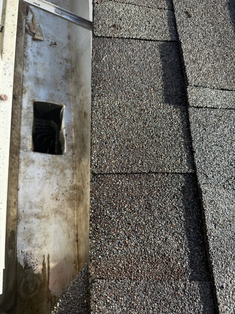 Close-up of clogged gutter with debris and roof grit before cleaning in Ocala FL