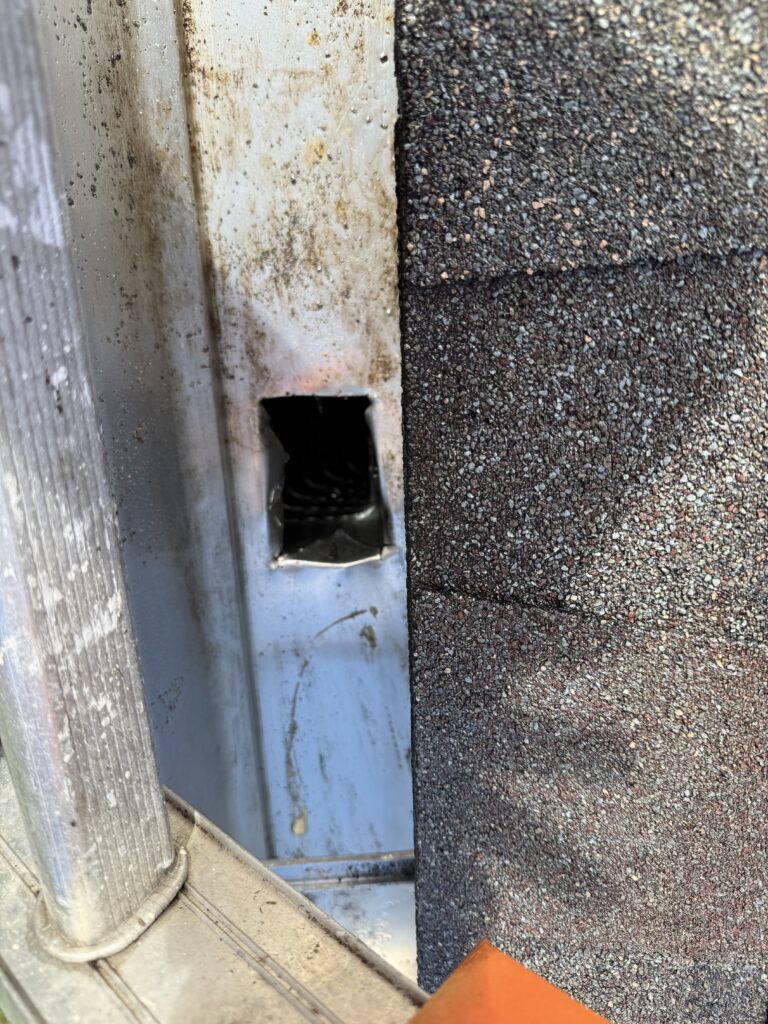 Clogged gutter downspout opening with debris blockage before cleaning in Ocala FL