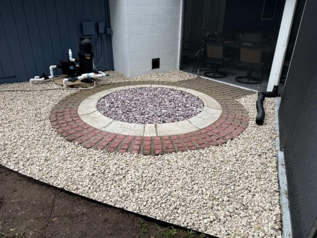 Stone medallion centered in finished pea gravel and brick rock install in Ocala FL