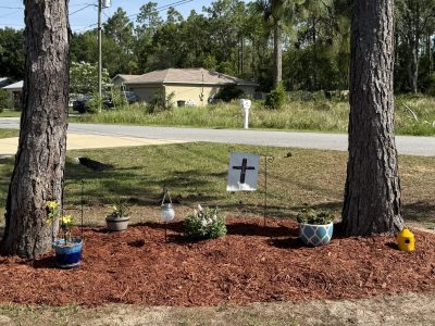 Tree-base memorial garden bed with fresh red mulch and solar accents in Ocala FL