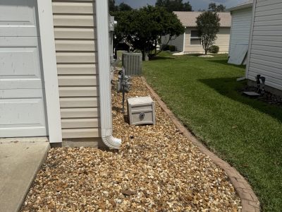 Side utility yard with electric meter and rock ground cover in Ocala FL