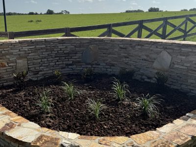 Stacked stone raised planter bed freshly planted with groundcover in Ocala FL